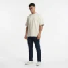 Firefly_GeminiFlash_Model wearing dark navy chino. white studio background. 928913